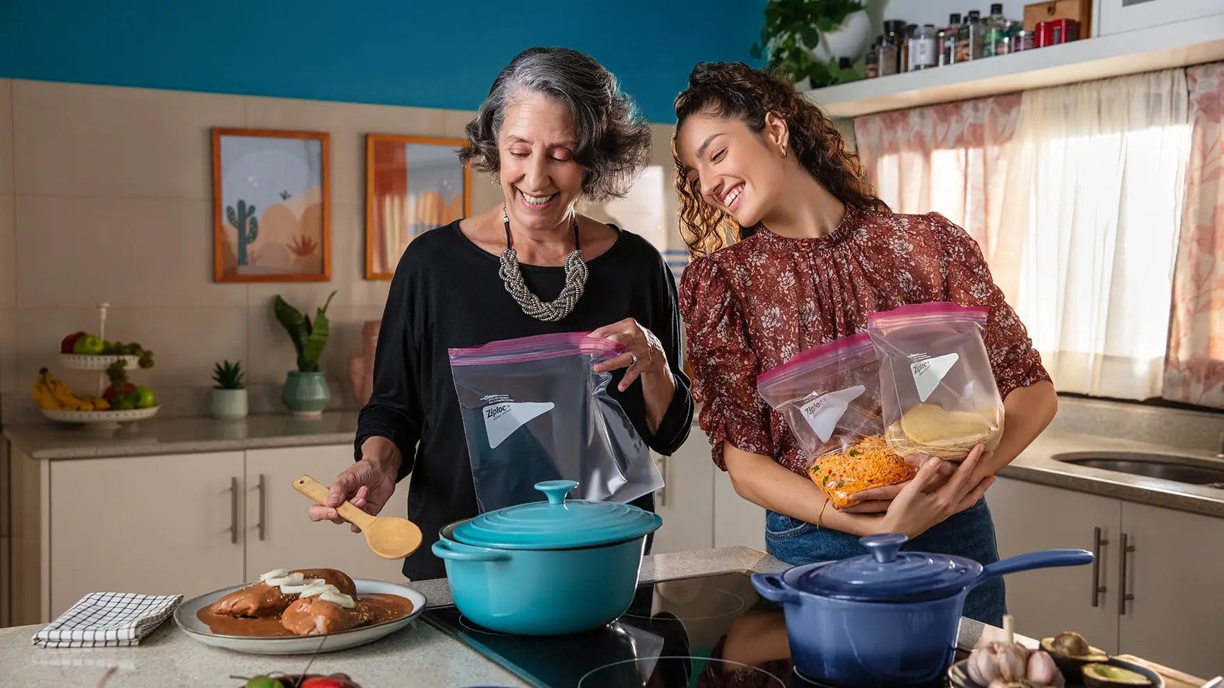 Two women in kitchen adding food into Ziploc® bags