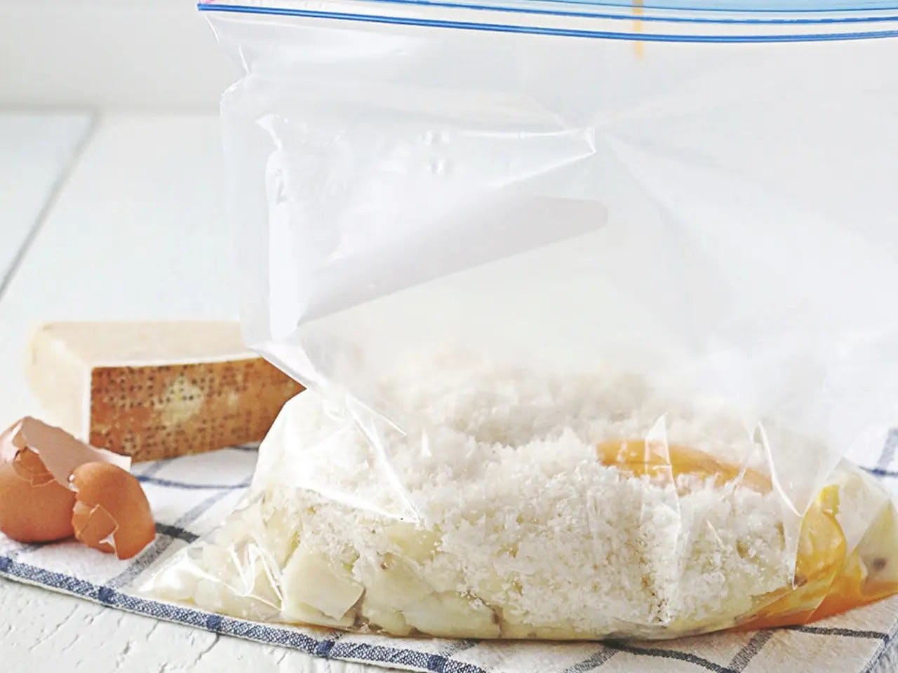 Yemas de huevo vertidas en una bolsa Ziploc con papas, harina, queso y sal