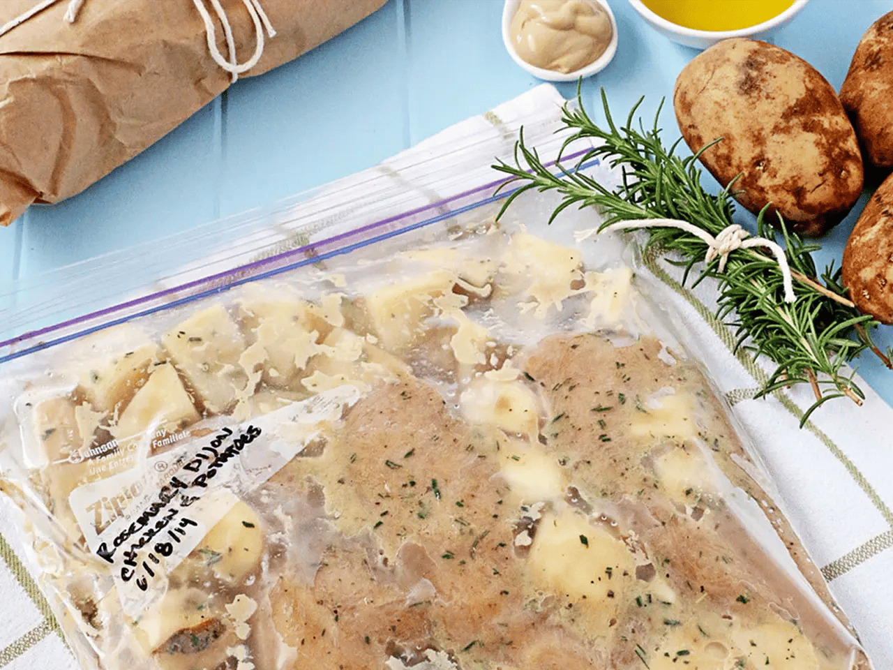 Close up of rosemary dijon chicken and potatoes in Ziploc bag.